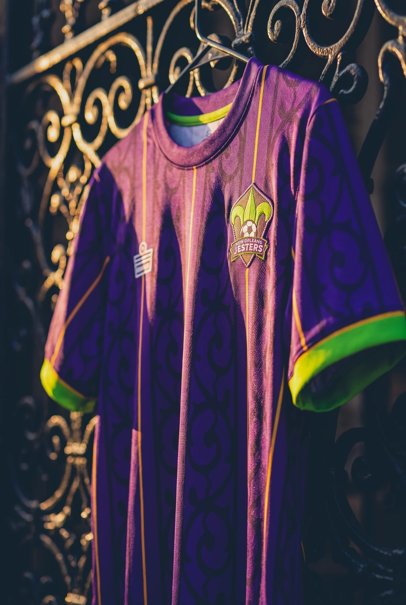 Purple Jesters home shirt hanging against ornate ironwork